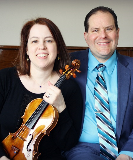 Kelly and Darryl seated, Kelly holding violin
